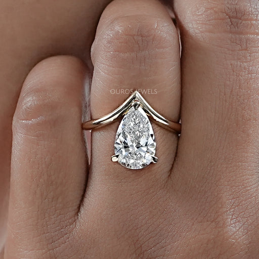 front angle of v shape pear cut diamond solitaire engagement ring in finger