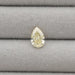 2.17 Carat Fancy Yellow Pear Cut Loose Diamond displayed on a gray textured background, highlighting its unique shape and brilliant color.