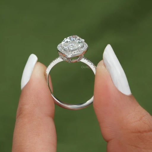 close view of marquise cut lab diamond halo engagement ring on grey fabric