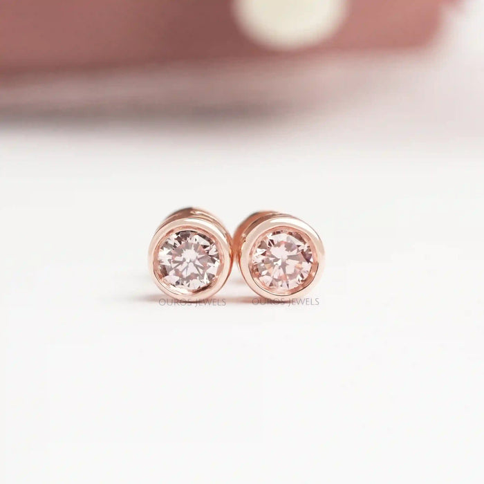 Bezel Set Diamond Stud Earrings in rose gold, showcasing sparkling round diamonds with a sleek and modern design displayed on white surface.