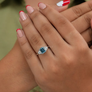 In finger front look of blue emerald cut lab diamond 3 stone engagement ring