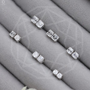 Asscher Cut Diamond Stud Earrings in various sizes arranged diagonally on a gray velvet jewelry tray.