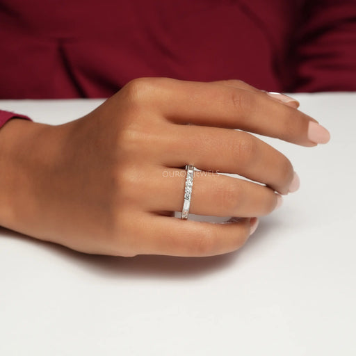 Baguette And Round Diamond Eternity Wedding Band shown on a woman's hand, highlighting the alternating round and baguette-cut diamonds in a sleek and elegant setting.