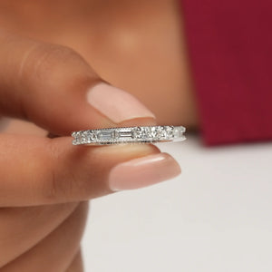 A women is holding Baguette And Round Diamond weeding Band in between two fingers.