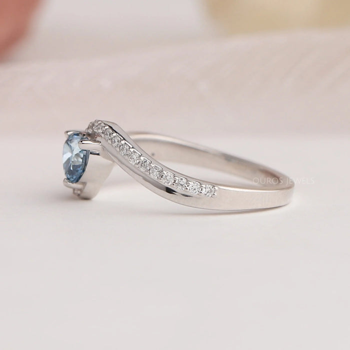 Side view of diamond heart shaped ring with curved band, this engagement ring set in bypass & side accents diamonds.