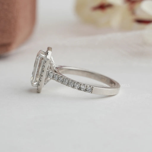emerald cut lab diamond halo engagement ring's side view on grey fabric