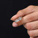 A Men Holding 8 Stone Round Diamond Men's Wedding Band with dark background.