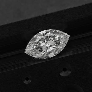 2.50 Carat Marquise Cut Loose Diamond placed on a dark wooden surface, emphasizing its detailed facets and clarity.