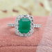 Natural green emerald cut gemstone engagement ring with halo setting in solid white gold