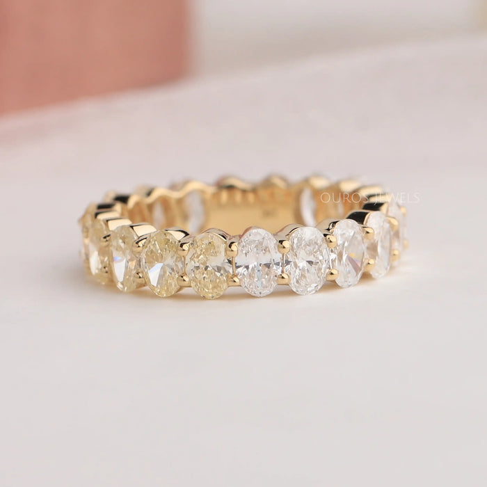 Brilliant oval cut lab made diamond eternity ring with prongs set in solid yellow gold