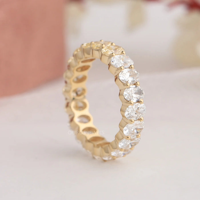 Side look of prongs and oval brilliant cut lab diamonds in eternity band