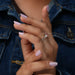 In finger side look of 3 stone radiant cut diamond engagement ring with pear shaped side stones