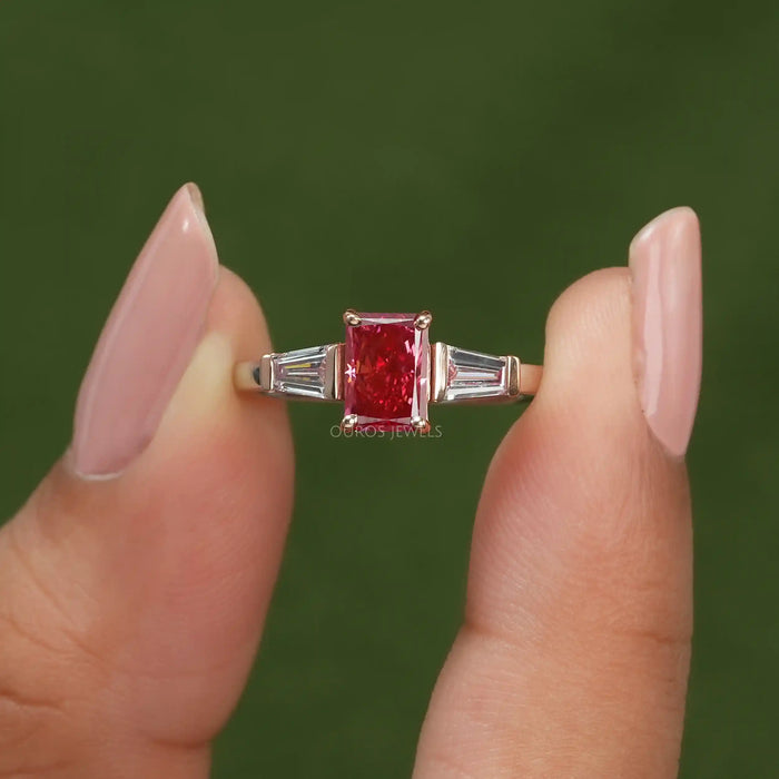 Close up look of pink radiant and tapered baguette cut three stone engagement ring