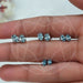 Blue Oval Cut Lab Diamond Stud Earrings displayed on a hand, featuring various sizes.