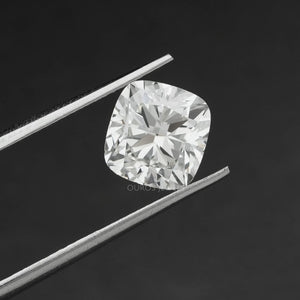 2.5 Carat Cushion Cut Loose Diamond hold by tweezers against a black background.