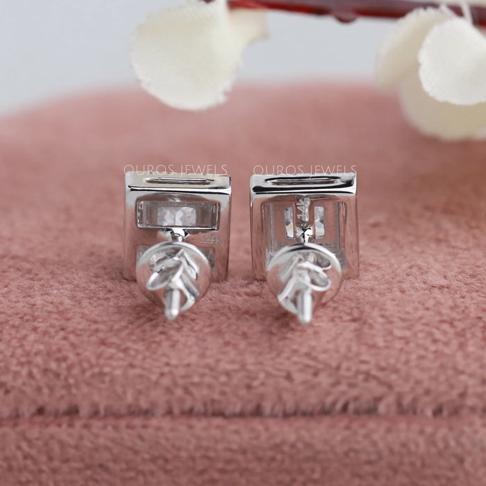 Back side of princess diamond halo earrings showing 14k white gold mark and screw back setting