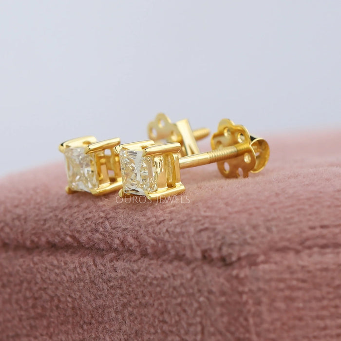 Striking 14k yellow gold screw back earrings encrusted with a brilliant princess cut lab diamond in VS clarity.